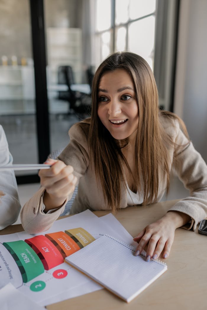 Young woman excitedly discussing ideas in a modern office setting.